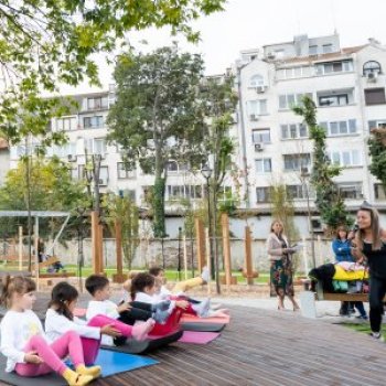 Children doing yoga on mats with an adult instructor